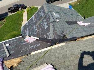 Roof replacement in progress by Elite Roofing & Solar: Workers are removing damaged shingles and installing new roofing materials in Denver, CO