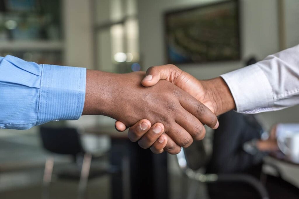 Two men shaking hands agreeing to do business with Elite Roofing.