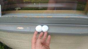 Hail damage on a roof caused by a severe storm, highlighting the increasing frequency and intensity of extreme weather events due to climate change in Denver, CO