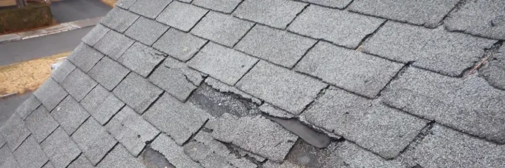 Wind damage to roof with lifted, broken asphalt shingles exposing underlayment by Elite Solar in Michigan