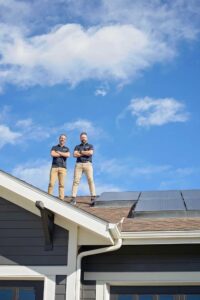 Team members of Elite Roofing & Solar, standing on a roof doing a roofing inspection in Denver, CO