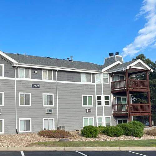 Modern multifamily condo building with new gray roof and well-maintained exterior, demonstrating the benefits of HO6 condo insurance for property owners, Elite Roofing & Solar.