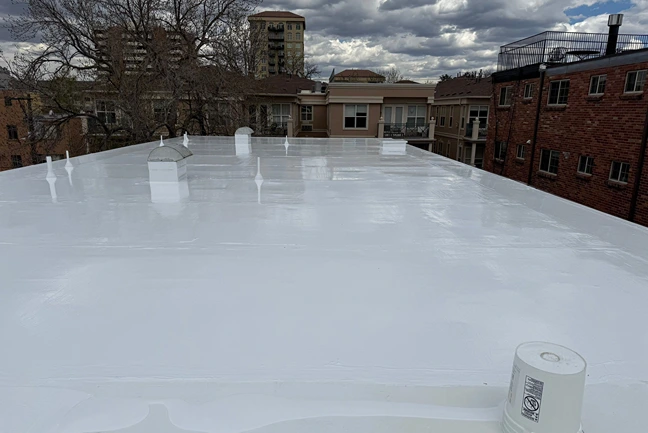 Smooth, freshly completed white commercial roof coating showcasing professional finish by Elite Roofing and Solar in Gaco