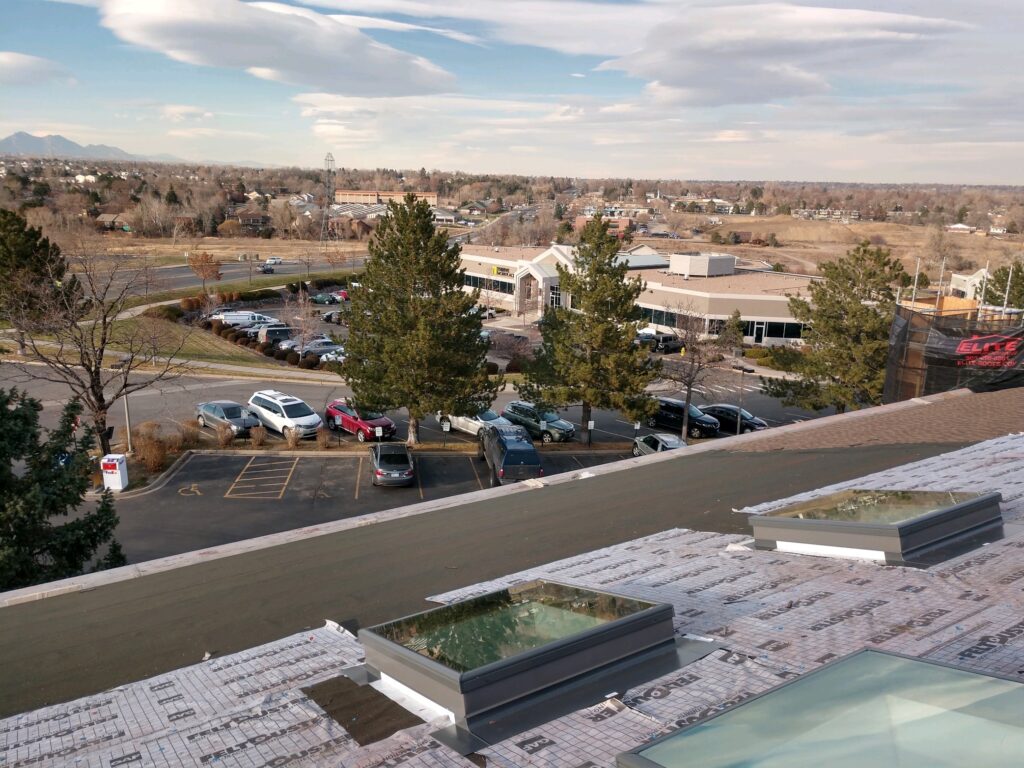 Roofing contractor’s commercial roof renovation project with skylight installations and roofing materials prepared by Elite Solar