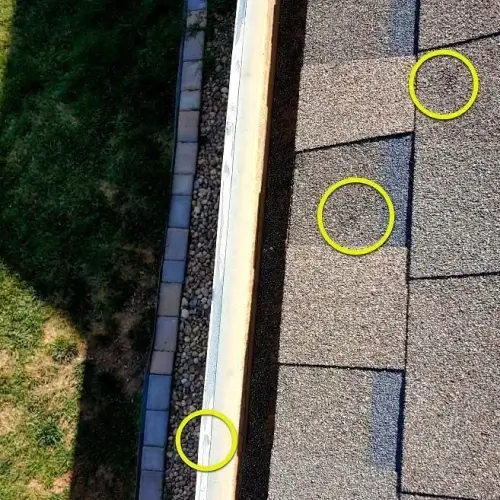 Shingle roof and gutter with yellow circles highlighting hail impact marks, illustrating when to report hail damage on roof by Elite Roofing & Solar