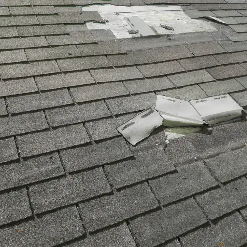 Wind damage to roof in Michigan with torn and missing shingles exposing damaged underlayment by Elite Solar in Michigan