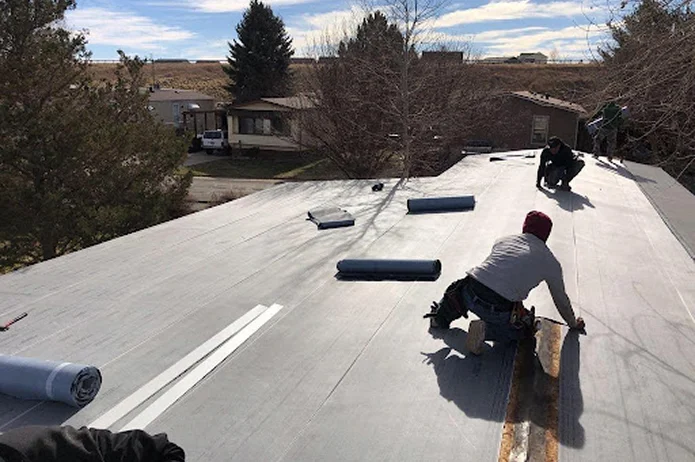 Professional roofers installing flat roofing system by Elite Roofing and Solar in CO