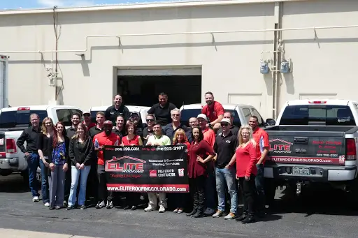 Elite Solar team providing professional roofing and solar services in Greeley, Michigan, standing together in front of company service vehicles.