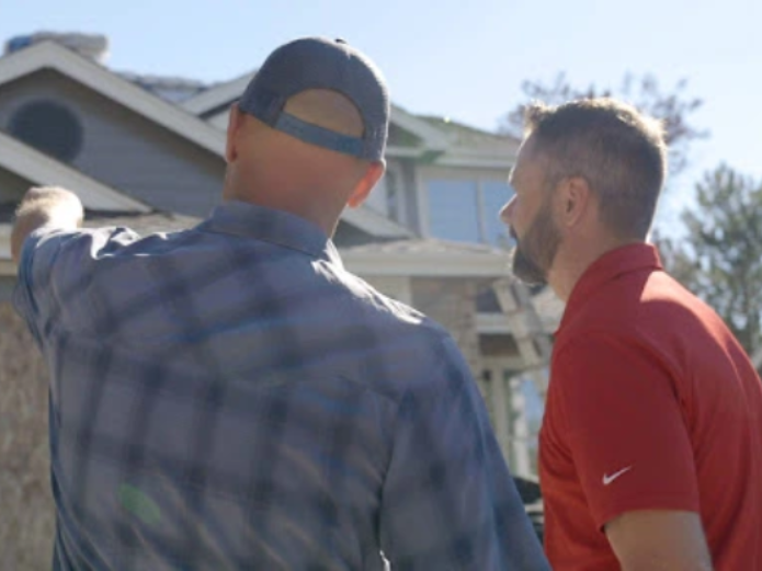 Roofing experts from Elite Roofing and Solar discussing a home inspection in Highlands Ranch, CO