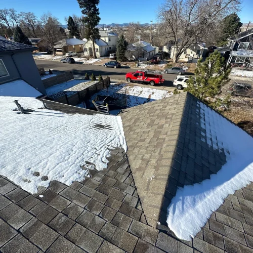 Roof inspection showing snow buildup and shingle condition for winter preparation by Elite Roofing and Solar