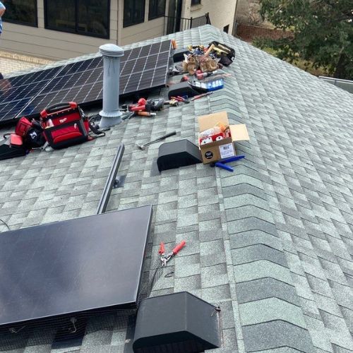 Elite Roofing & Solar performing maintenance on a solar panel on a Denver residential home