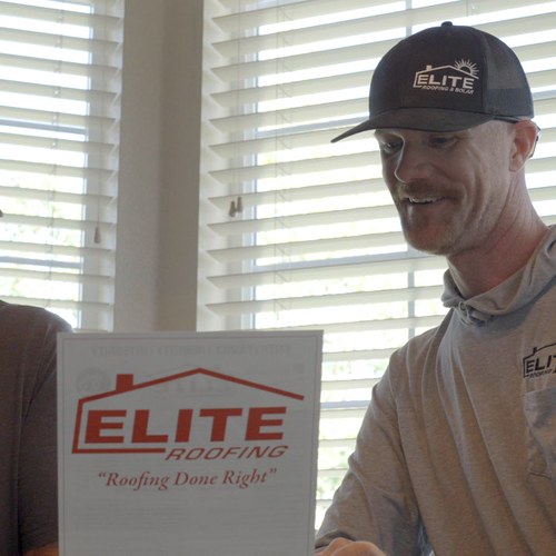 Homeowner reviewing a roof estimate with an Elite Roofing & Solar professional at a table