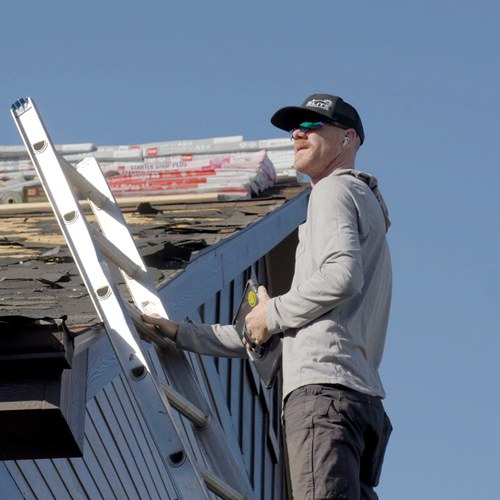 Elite Roofing & Solar professional on a roof with a tablet during a second-opinion inspection
