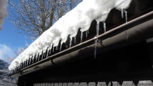 A roof in winter with snow and icicles