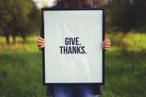 Woman holding Give Thanks sign
